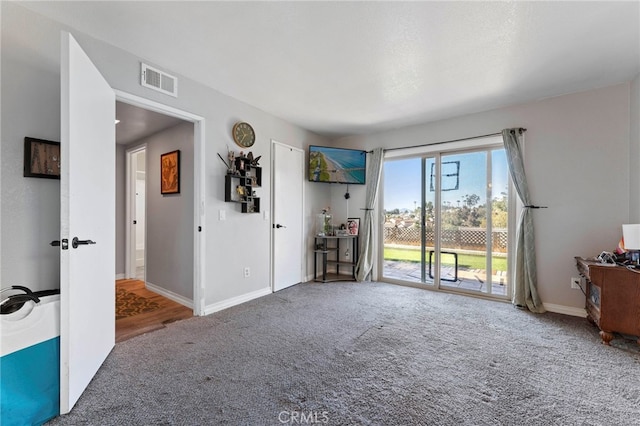 interior space with baseboards, visible vents, and carpet flooring