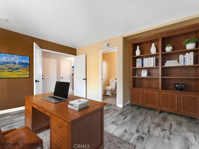 home office featuring baseboards, visible vents, and light wood-style floors