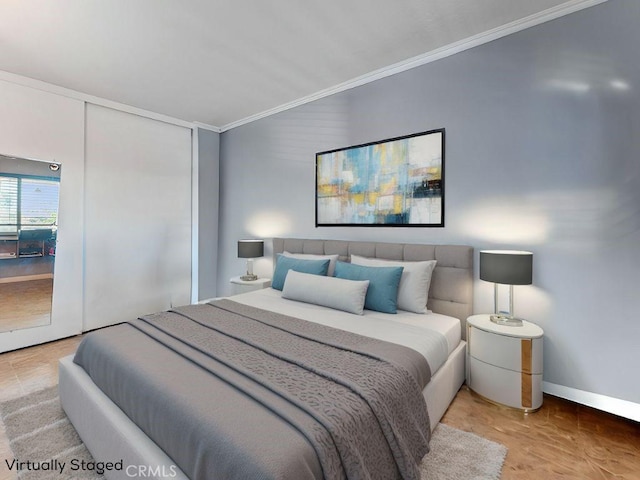 bedroom with a closet, crown molding, and baseboards