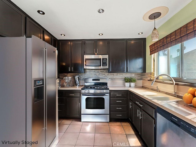 kitchen featuring light tile patterned flooring, stainless steel appliances, a sink, light countertops, and tasteful backsplash