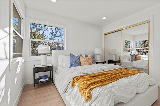 bedroom with light hardwood / wood-style floors and a closet