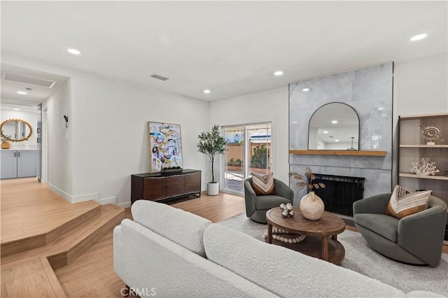 living room featuring a large fireplace and wood-type flooring