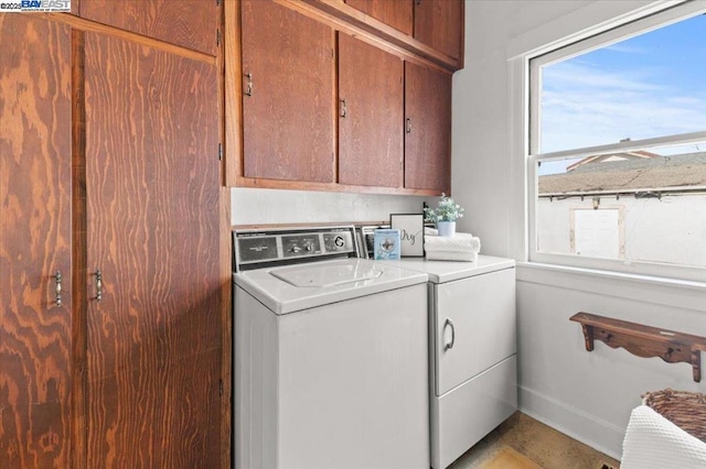 washroom with washer and dryer and cabinets