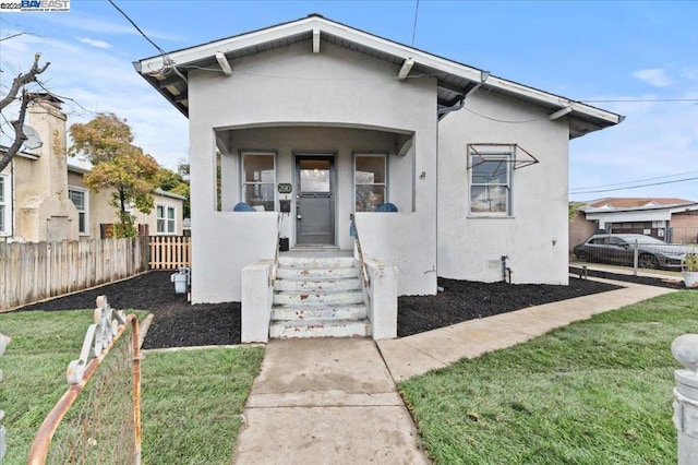 bungalow featuring a front lawn and a porch