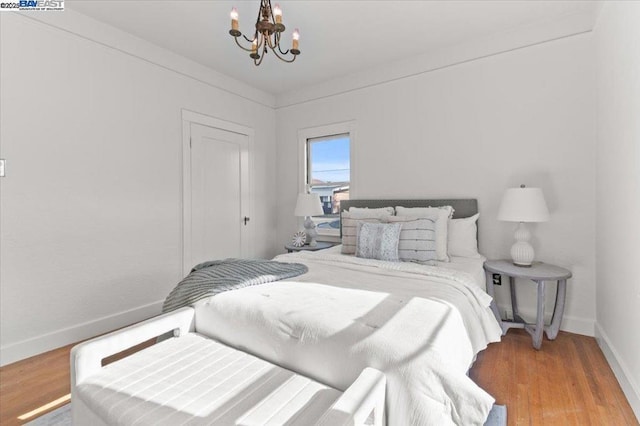 bedroom with hardwood / wood-style flooring and a chandelier