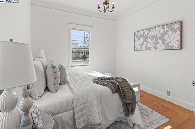 bedroom featuring an inviting chandelier and hardwood / wood-style floors