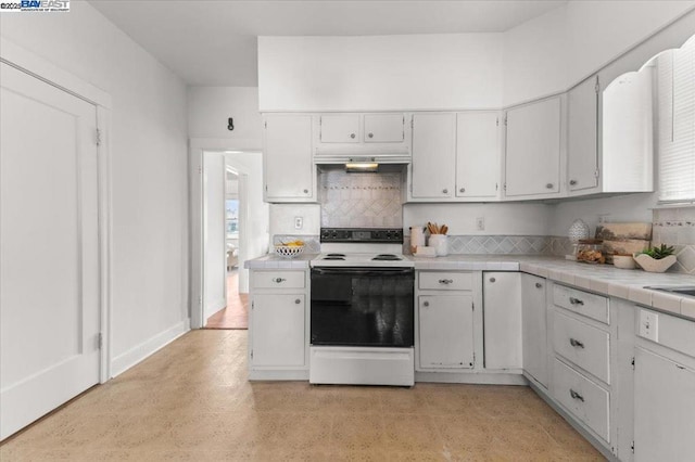 kitchen with white electric range, tile counters, decorative backsplash, and white cabinets