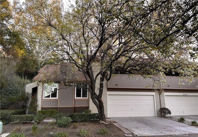 view of front of home featuring concrete driveway, a garage, and stucco siding