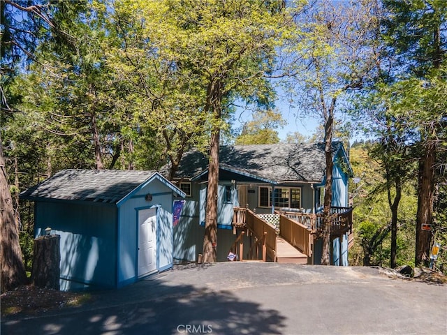 view of front of house featuring a wooden deck and a storage unit