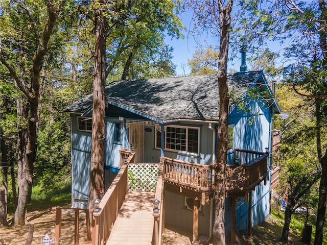 rear view of property featuring a wooden deck