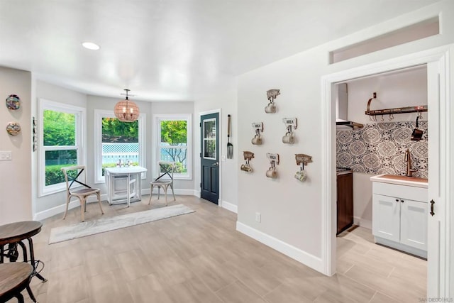 dining room with sink, a notable chandelier, and light hardwood / wood-style floors