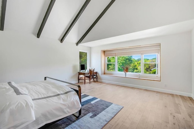 bedroom with lofted ceiling with beams and light hardwood / wood-style flooring