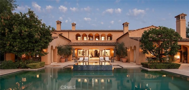 back house at dusk with a patio