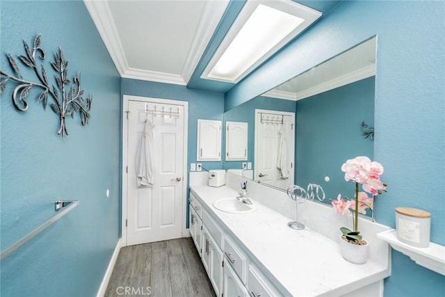 bathroom with vanity, hardwood / wood-style floors, and ornamental molding