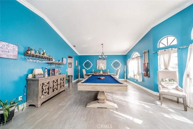 playroom with billiards, lofted ceiling, wood-type flooring, ornamental molding, and a notable chandelier