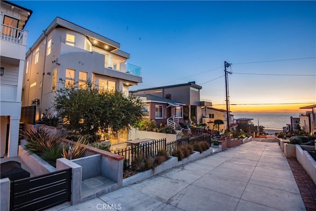 patio terrace at dusk featuring a water view