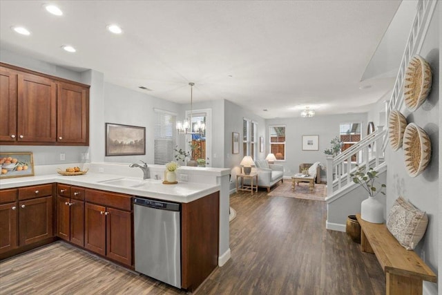 kitchen with pendant lighting, dishwasher, sink, kitchen peninsula, and dark wood-type flooring