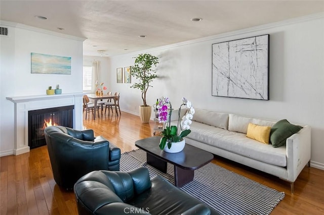 living room featuring hardwood / wood-style flooring and crown molding