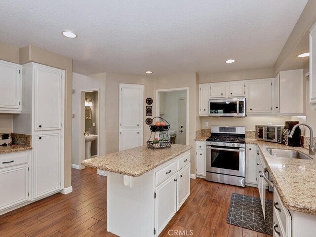 kitchen with white cabinetry, sink, a kitchen island, and appliances with stainless steel finishes