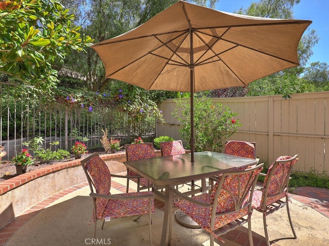 view of patio with a fenced backyard and outdoor dining area