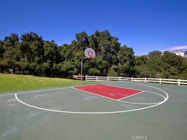 view of sport court with community basketball court, a lawn, and fence