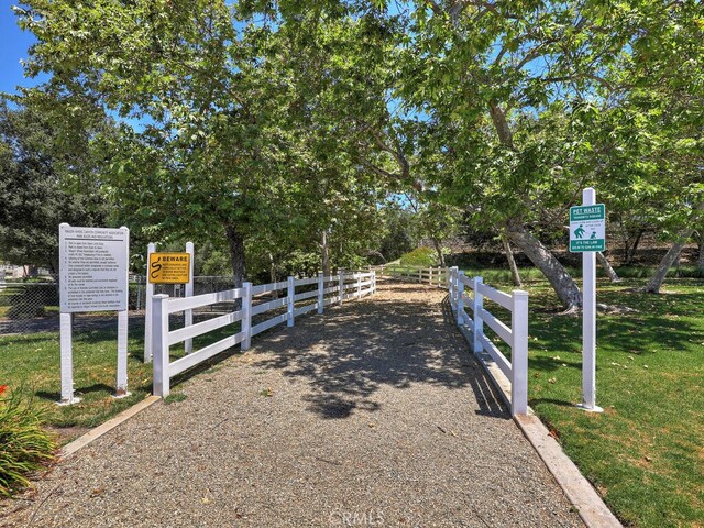 view of gate with a lawn and fence