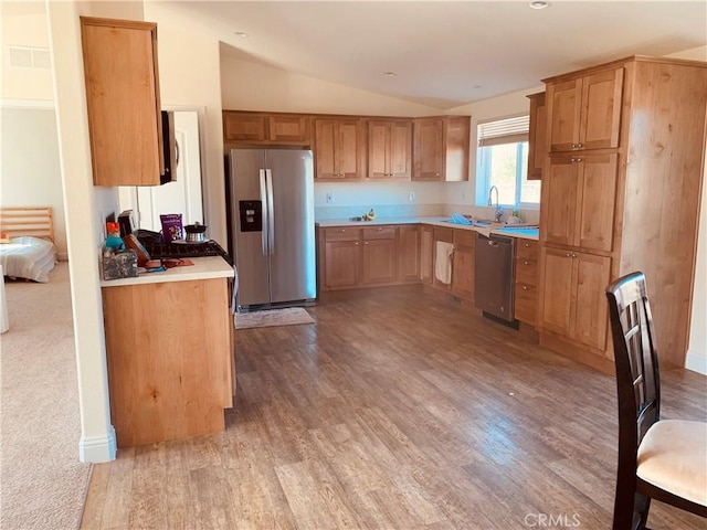 kitchen featuring lofted ceiling, light countertops, visible vents, appliances with stainless steel finishes, and light wood-type flooring