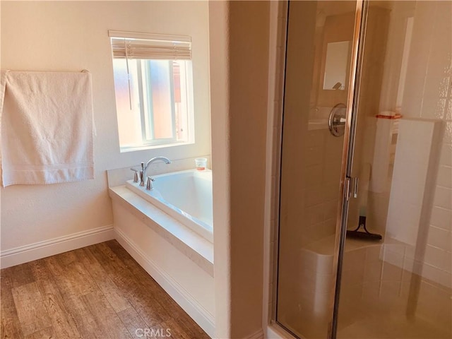 full bath with a garden tub, a shower stall, baseboards, and wood finished floors