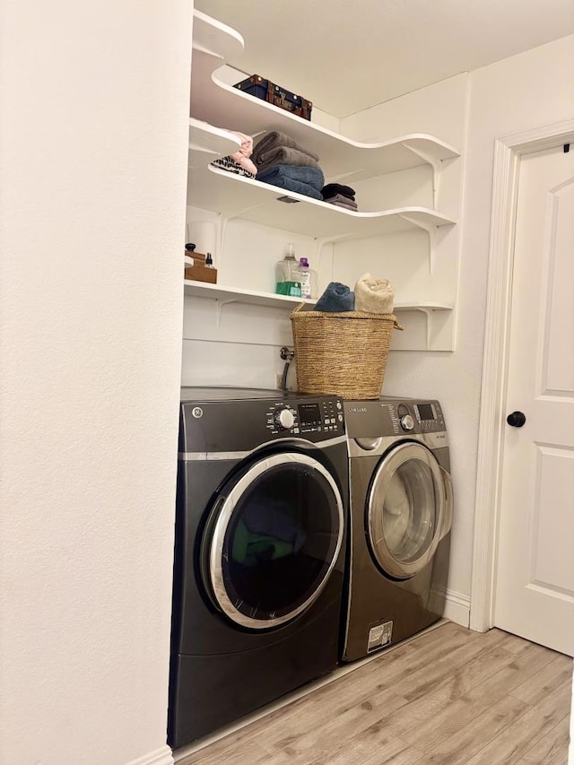 laundry area featuring light wood-type flooring and independent washer and dryer