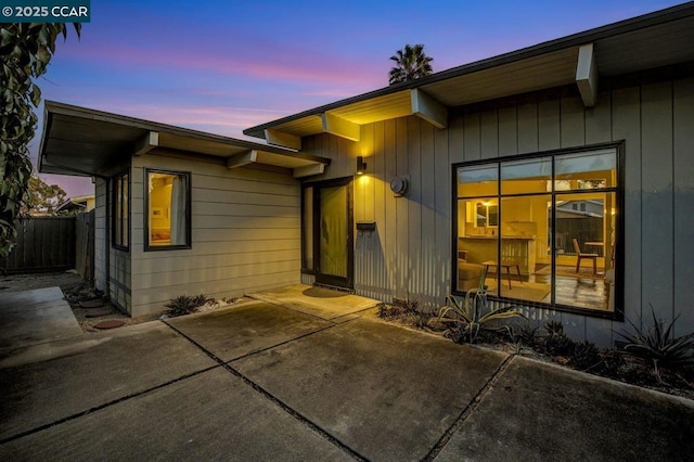 exterior entry at dusk featuring a patio