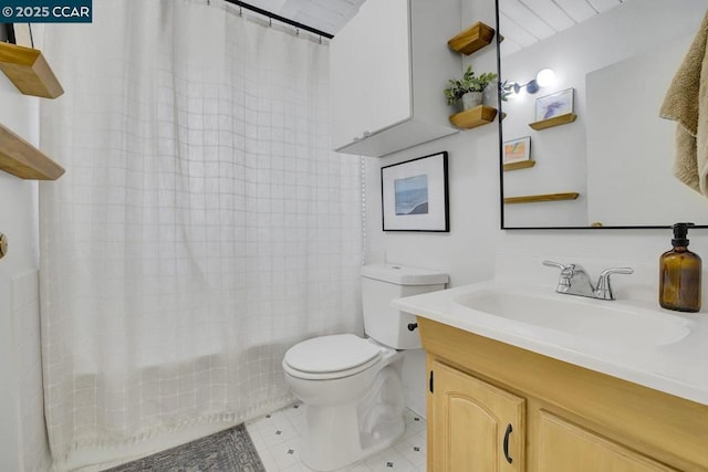 bathroom with tile patterned flooring, vanity, and toilet