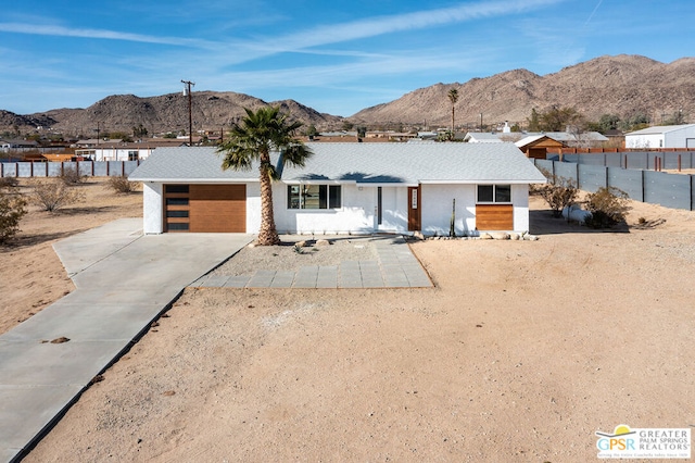 ranch-style house featuring a garage and a mountain view