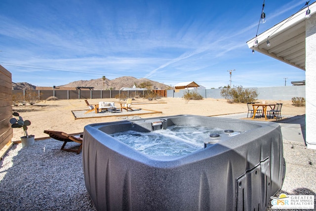 view of yard with a mountain view and a hot tub