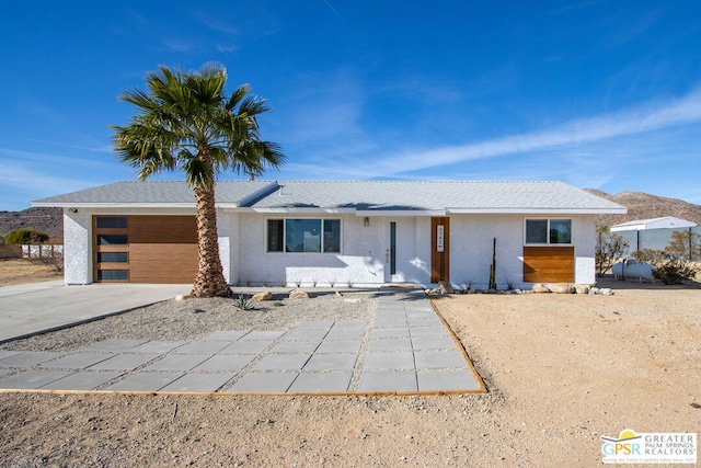 single story home with a garage and a mountain view