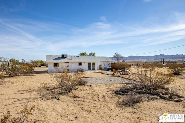 rear view of house with a patio and a mountain view