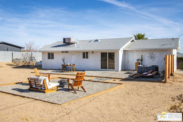 back of property with central AC unit, a fire pit, and a patio