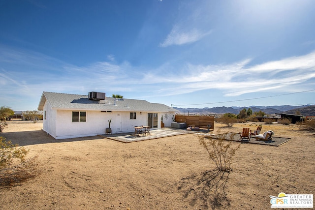 back of property featuring a patio, a mountain view, and central AC unit