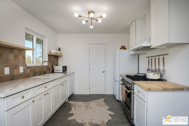 kitchen featuring white cabinetry, sink, decorative backsplash, wall chimney range hood, and white appliances