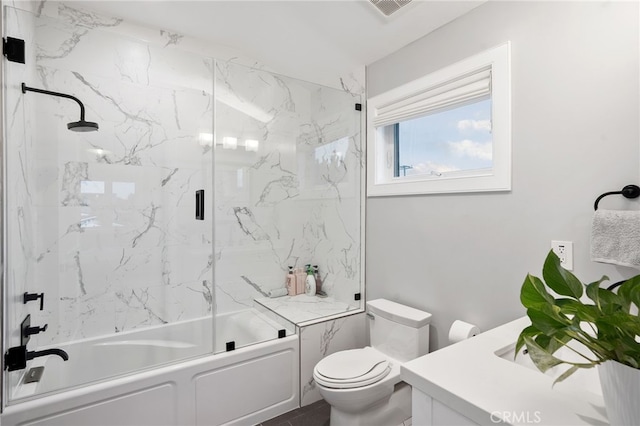 full bathroom featuring vanity, shower / bath combination with glass door, and toilet