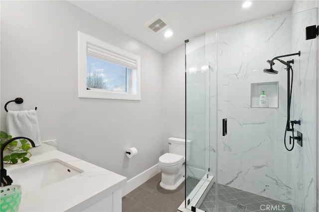 bathroom featuring tile patterned floors, vanity, toilet, and a shower with door