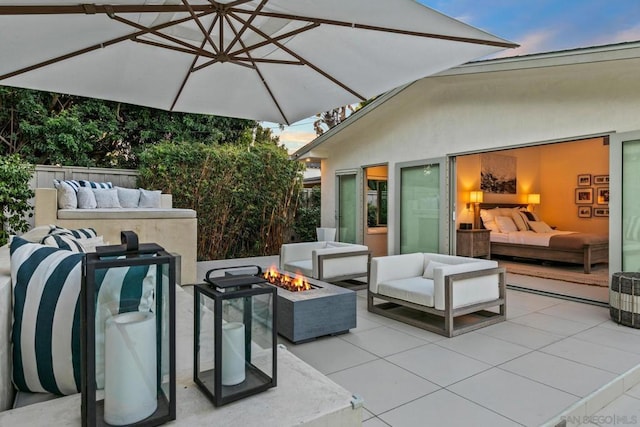 patio terrace at dusk featuring an outdoor living space with a fire pit