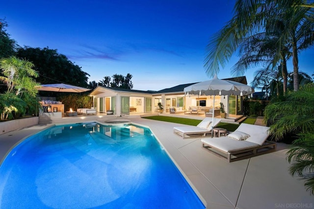 pool at dusk with an outdoor living space, an outdoor structure, and a patio