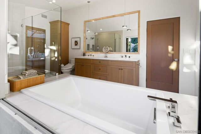 full bathroom featuring vanity, shower with separate bathtub, and toilet