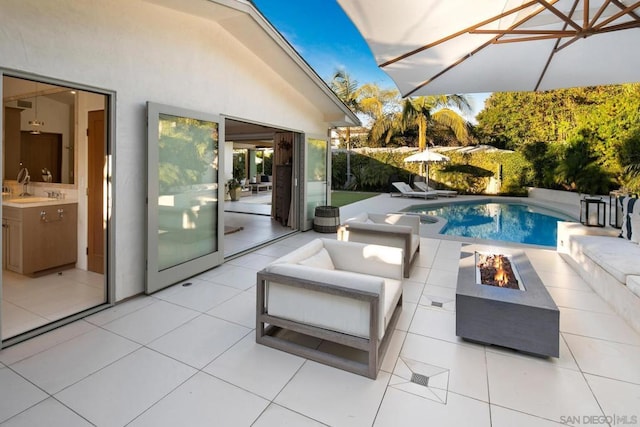 view of pool featuring sink, a patio area, and a fire pit