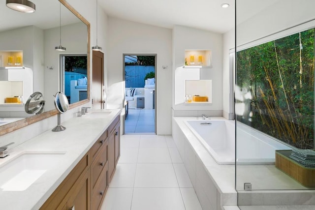 bathroom featuring vanity, tile patterned flooring, vaulted ceiling, and tiled tub