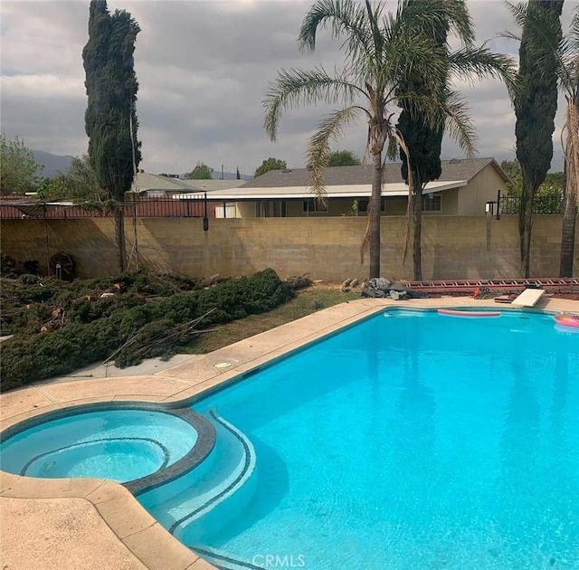 view of swimming pool featuring an in ground hot tub