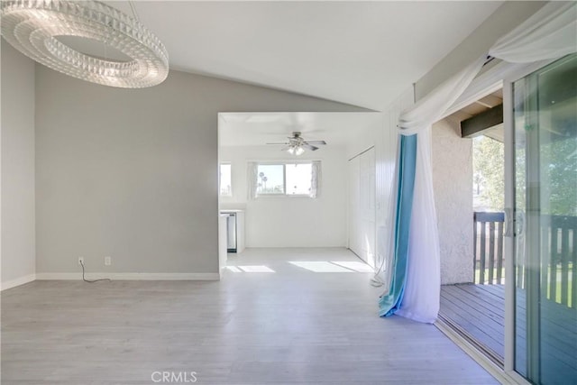 spare room with ceiling fan, vaulted ceiling, and light wood-type flooring