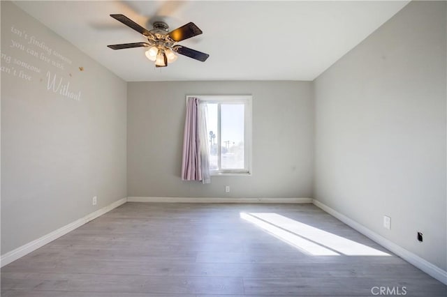 empty room with ceiling fan and light hardwood / wood-style floors