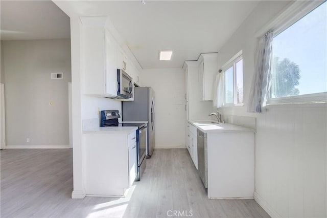 kitchen featuring white cabinetry, stainless steel appliances, light hardwood / wood-style floors, and sink