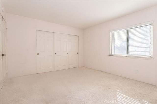 unfurnished bedroom with carpet floors and a closet